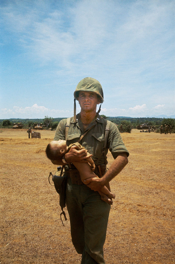 Photographie de collection représentant un marine américain avec un enfant au Vietnam, Atelier Galerie Taylor à Paris.