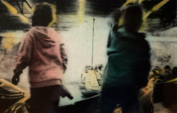 Photographie colorisée d'Irène Jonas de deux enfants devant un stand d'auto tamponneuses, Atelier Galerie Taylor à Paris.